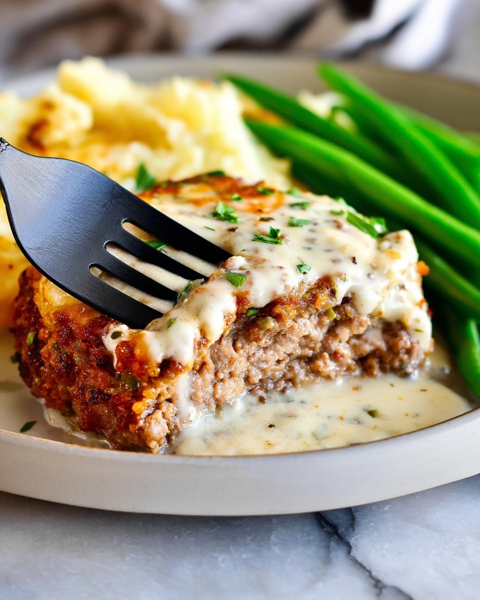 The image shows a close-up of a white plate with two layers visible in the main dish: a crispy golden-brown meat layer on the bottom and a creamy white sauce layer on top, speckled with herbs. A black fork is stuck into the meat layer, lifting a piece to show its texture clearly. To the right of the dish, bright green beans add a fresh, vibrant contrast. The entire meal is placed on a white marbled surface, creating a clean and bright setting. Photo taken with an iphone --ar 4:5 --v 7