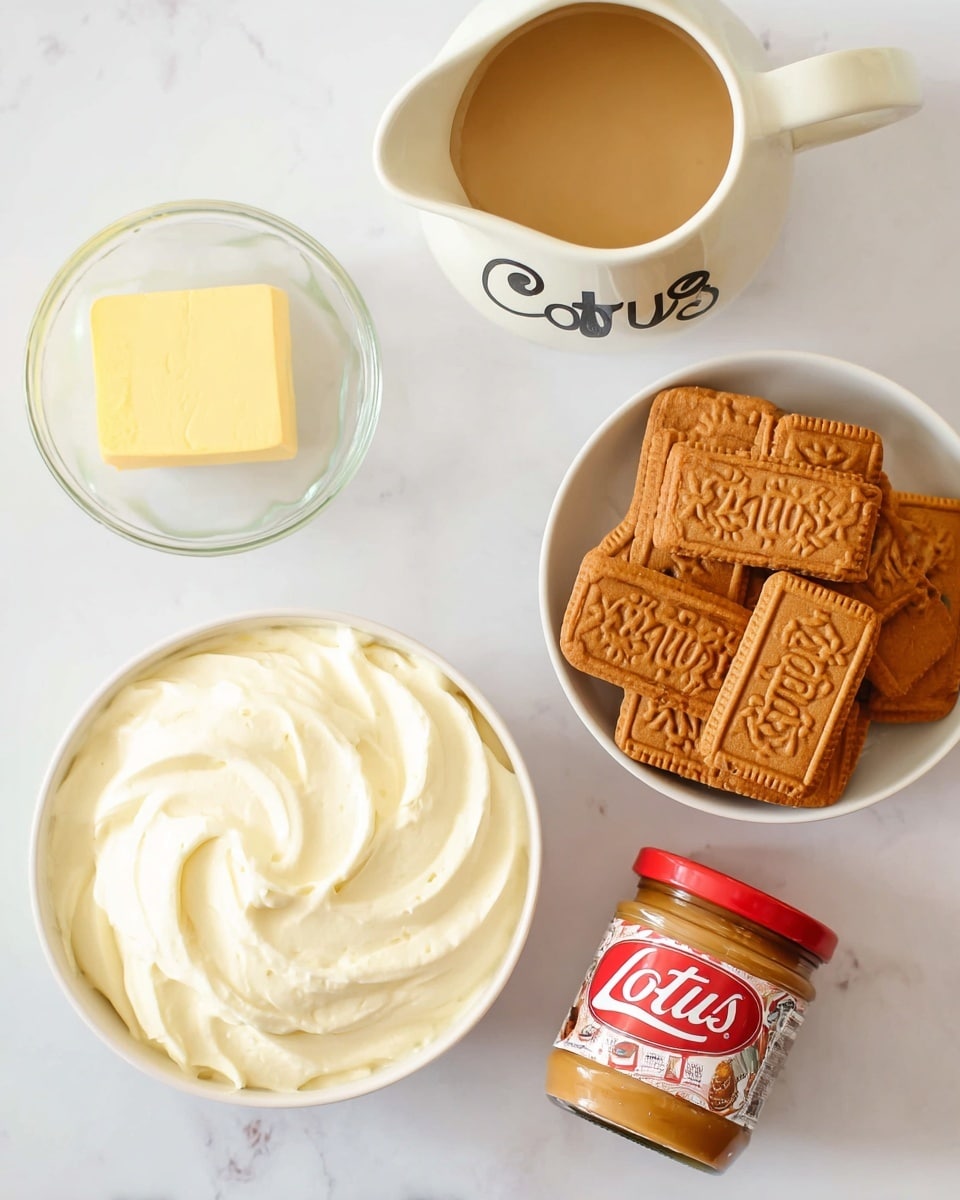 The image shows a top view of a collection of baking ingredients arranged neatly on a white marbled surface. On the right, there is a white bowl filled with multiple rectangular caramel-colored Lotus Biscoff cookies, stacked unevenly with visible
