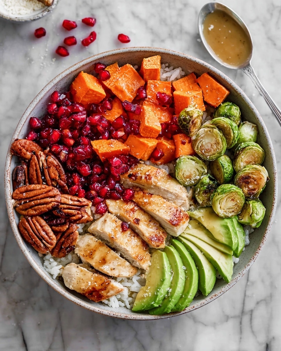 A white bowl holds a colorful layered dish. The bottom layer is white rice, topped with bright red pomegranate seeds scattered across the surface. On one side, there is a neat row of sliced avocado with a smooth green texture and light seasoning of black pepper. Alongside the avocado, there are orange roasted sweet potato cubes with a slightly crisp texture. Next to that, a group of green roasted Brussels sprouts with browned edges add a slightly rough texture. In the center, several grilled pieces of golden brown chicken are placed in a row, slightly glistening and seasoned with black pepper. To the left, there is a small pile of whole pecans with a glossy, textured brown surface. The bowl sits on a white marbled surface with a spoon nearby that has some light yellow sauce on it, and scattered pomegranate seeds around the bowl. Photo taken with an iphone --ar 4:5 --v 7