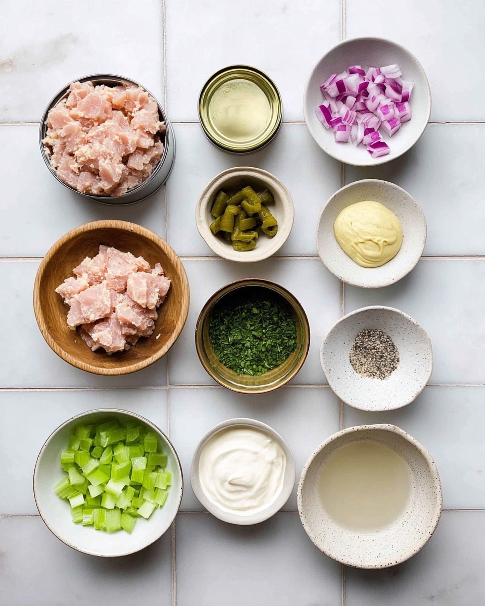The image shows nine small bowls and two open cans arranged neatly on a white marbled tile surface. The cans contain light pink tuna with a soft texture, positioned on the left side. The bowls hold various chopped ingredients: a wooden bowl with small purple-red onion cubes at the top center, a bowl with diced green pickles in the middle, a brown bowl with finely chopped dark green herbs at the bottom right, a small cup with diced light green celery near the bottom center, a bowl of white mayonnaise next to the cans, a bowl with coarse white salt and black specks to the right of the onions, a small white bowl holding pale yellow mustard below the salt, and a speckled white bowl on the far right with a clear liquid. All the items are placed on the white marbled tile surface. photo taken with an iphone --ar 4:5 --v 7