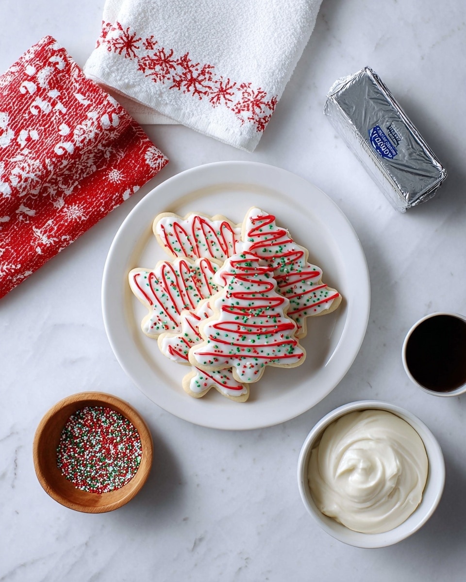 A white round plate holds a pile of Christmas tree-shaped cookies with white icing, decorated with red zigzag lines and small green and red sprinkles. To the left and above the plate, there are two folded kitchen towels, one red with white snowflakes and one white with red candy canes. To the right of the plate is an unopened silver butter block, and below the plate are a small wooden bowl filled with red, white, and green round sprinkles, a small dark cup with a liquid, and a white bowl filled with smooth white frosting. All items are placed on a white marbled surface. Photo taken with an iphone --ar 4:5 --v 7
