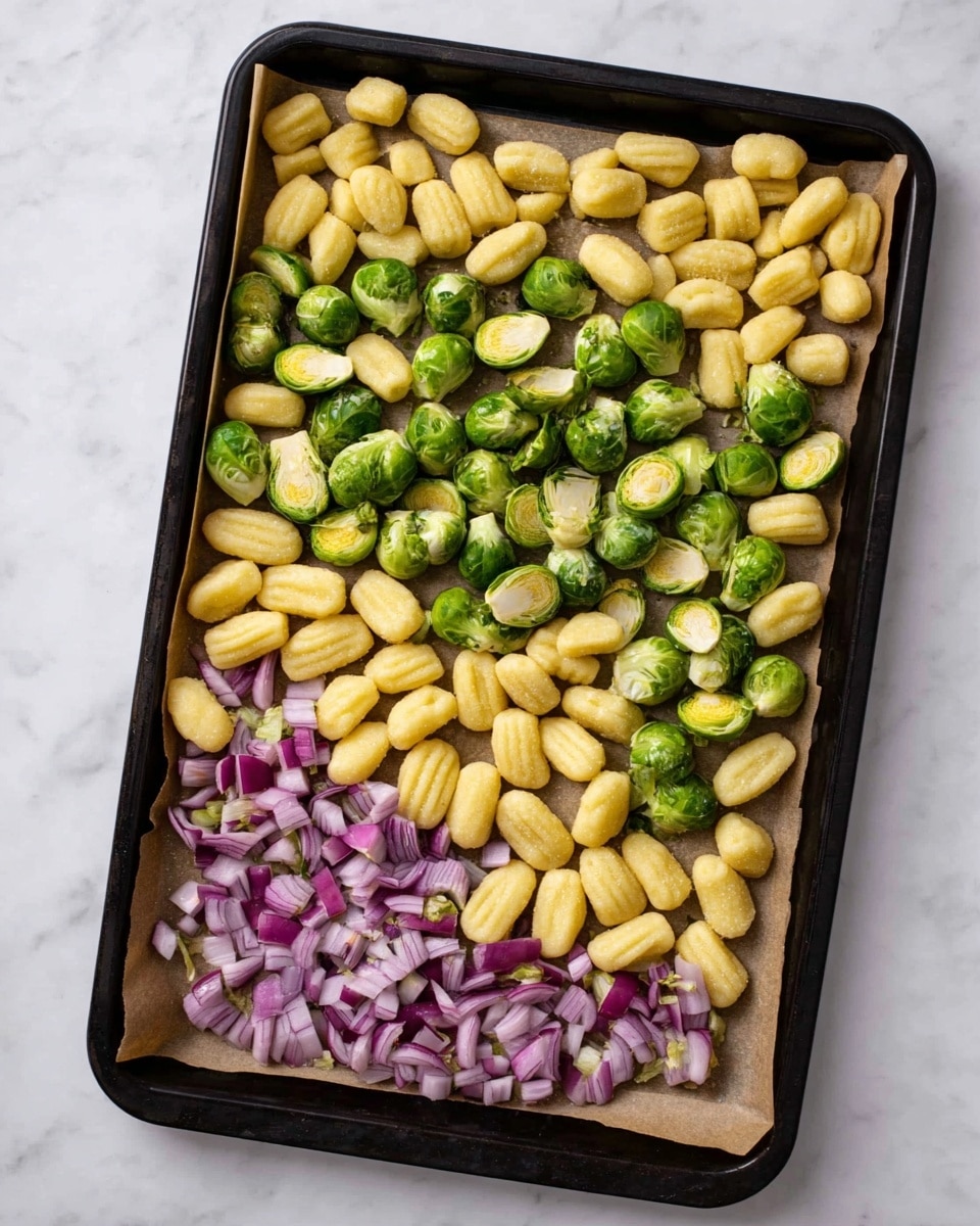 A black baking tray lined with brown paper is filled with three main layers of ingredients spread out evenly. The bottom and largest layer consists of small, oval-shaped, ridged yellow gnocchi pieces scattered across the tray. The middle layer is made up of green Brussels sprouts, some whole and some sliced in half, showing their fresh, round interiors. The top layer has medium-sized, roughly chopped purple onions spread intermittently, adding a soft contrast of color with their smooth texture. The tray sits on a white marbled texture surface. photo taken with an iphone --ar 4:5 --v 7