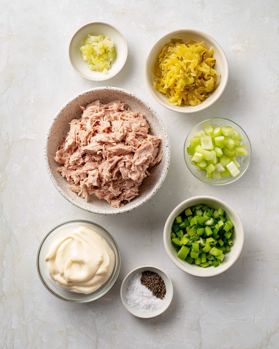 The image shows six small white bowls on a white marbled surface, each with different ingredients arranged in a loose circle. In the center is a large speckled bowl filled with pinkish shredded tuna. Above it is a bowl with yellow pickled shredded vegetables. To the right is a bowl containing small diced pale green celery pieces. Below that is a bowl of chopped green onions. Below the center bowl is a glass bowl with smooth, creamy white mayonnaise. Finally, near the bottom is a small glass bowl holding white granulated salt and black ground pepper side by side. The colors and textures are clearly visible and neatly arranged for preparation, photo taken with an iphone --ar 4:5 --v 7