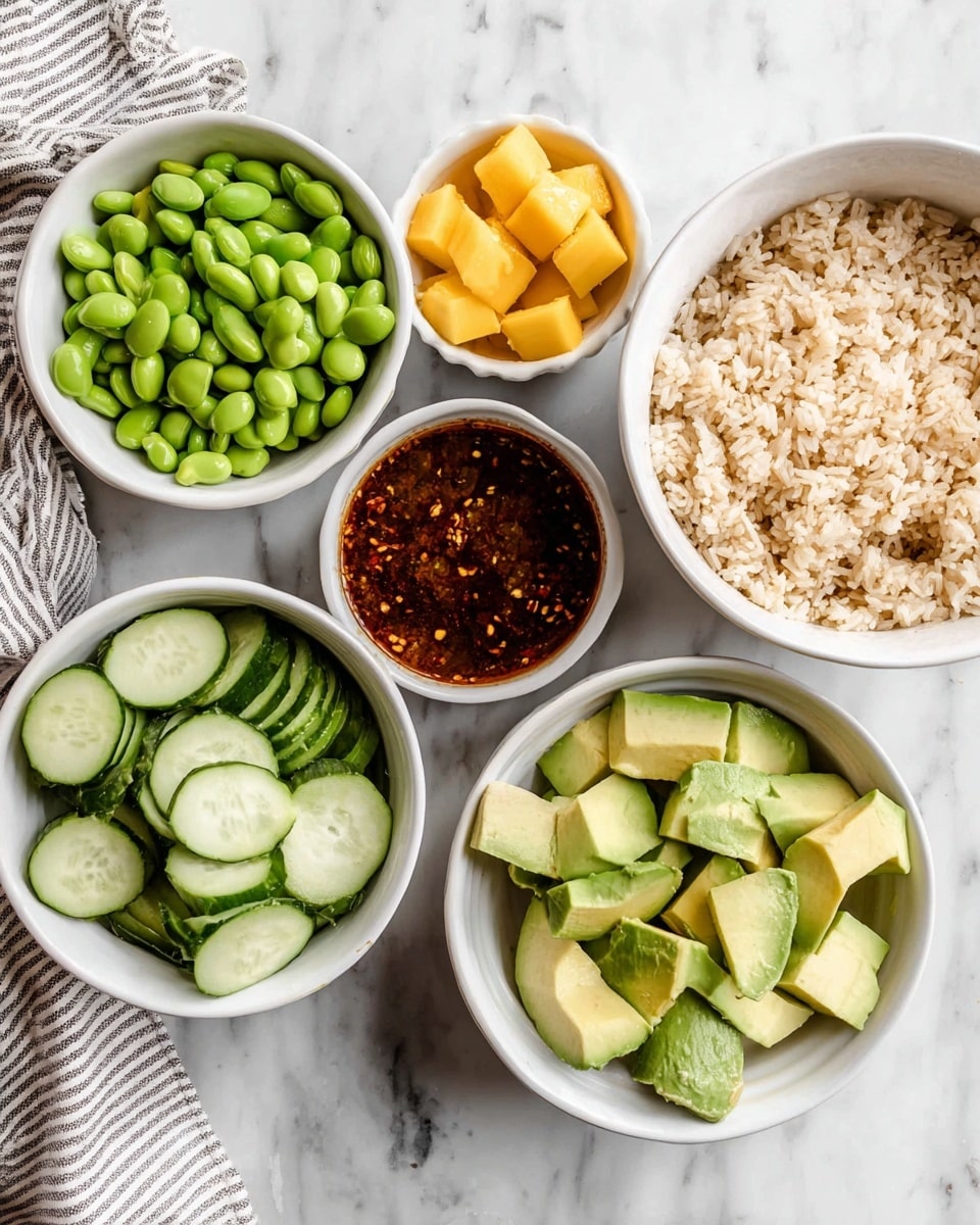 The image shows six white bowls placed on a white marbled surface. From left to right: a bowl filled with bright green edamame beans; a bowl with evenly sliced cucumber rounds, light green with darker green edges; a bowl with a thick dark reddish-brown sauce speckled with chili flakes visible inside; a smaller bowl with cubed light yellow mango pieces; a bowl with a peeled avocado sliced into neat square sections, light green with darker skin on top edges; and a larger bowl filled with fluffy light brown cooked rice. A striped cloth is partially visible in the top left corner. Photo taken with an iphone --ar 4:5 --v 7