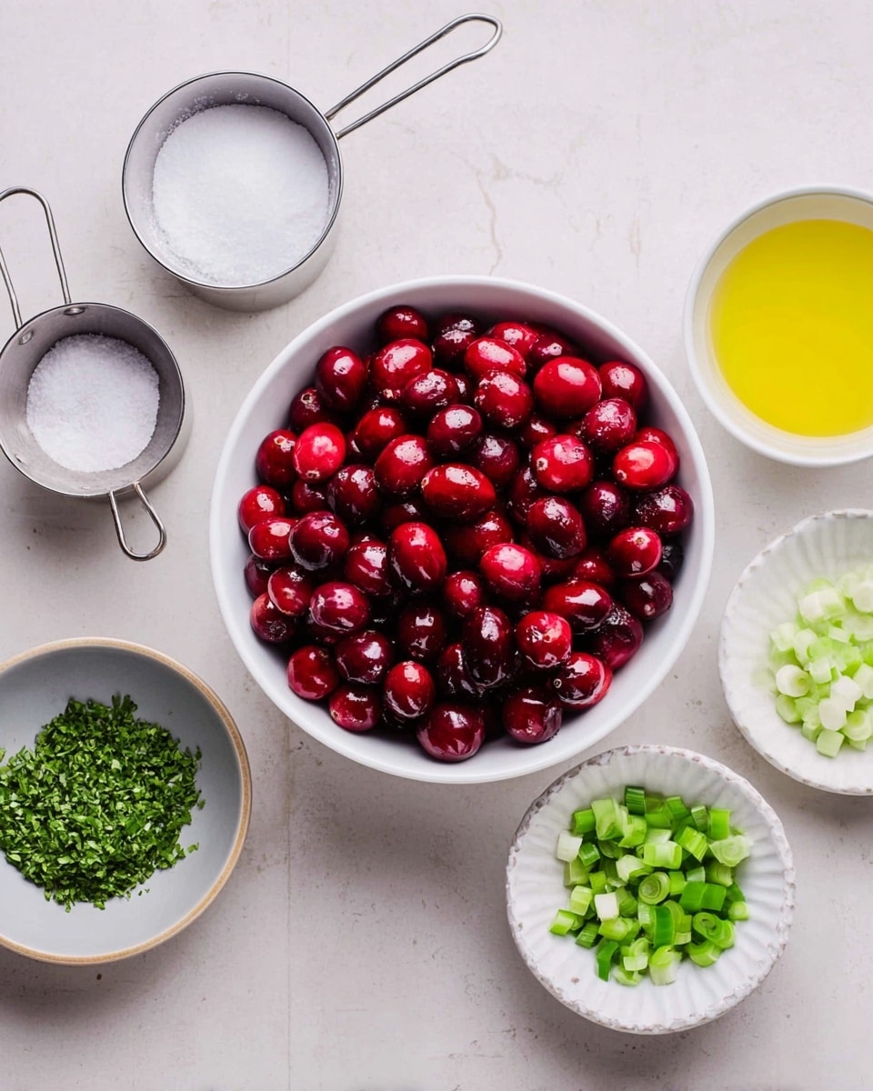 A white bowl filled with bright, shiny red whole cranberries is placed front and center on a light white marbled surface. Surrounding it in a semi-circle are six smaller containers: a metal measuring cup with sugar on the top left, a small gray bowl with salt just below it, a small white plate with finely chopped green zest on the bottom left, a metal measuring cup with chopped green herbs at the top right, a small white plate with diced green bell pepper to its right, a white fluted bowl with yellow lemon juice, and a metal measuring cup with chopped green onions tucked in near the bottom right. The arrangement is clean and organized, showing fresh ingredients ready to be mixed. photo taken with an iphone --ar 4:5 --v 7