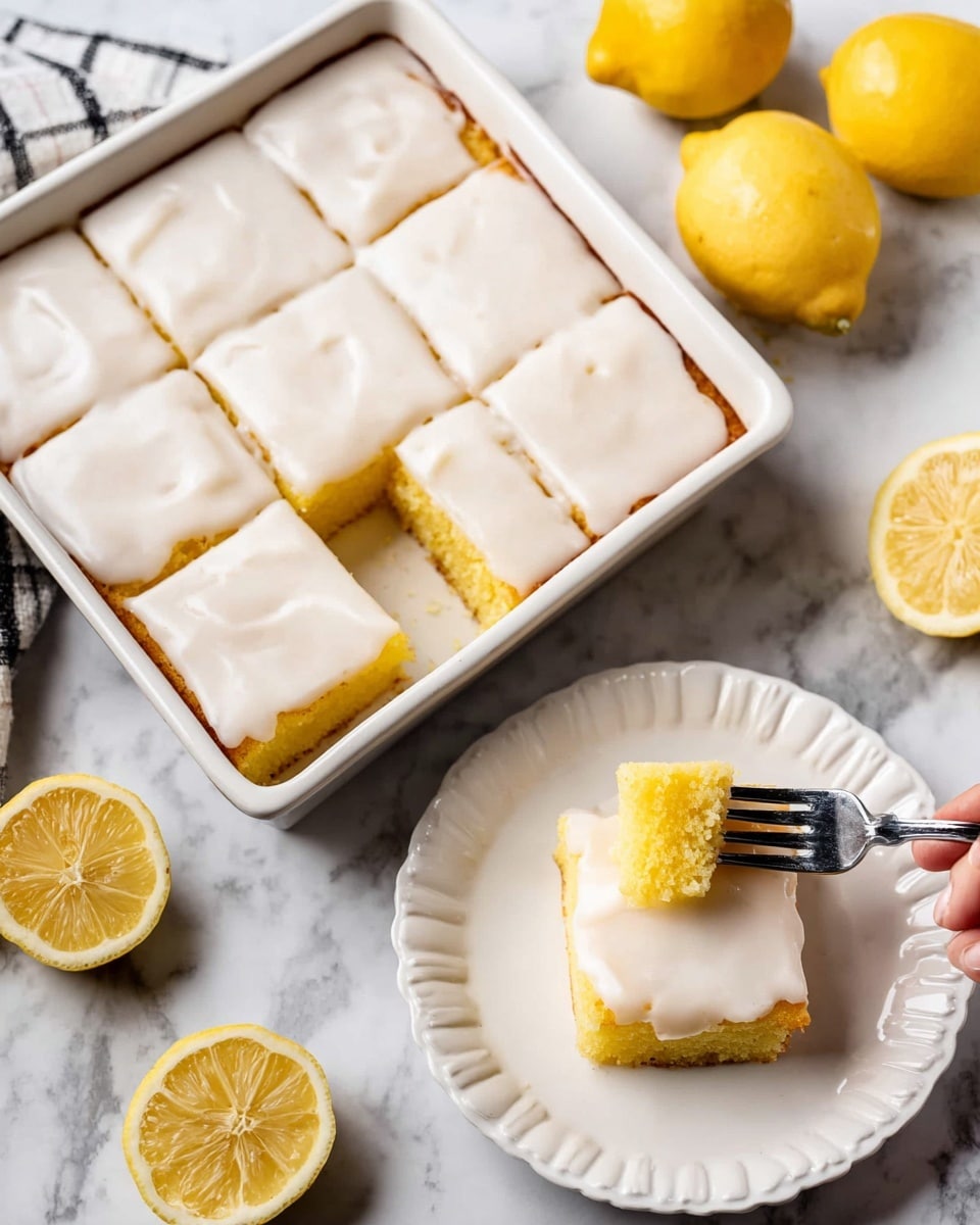 The image shows a square white baking dish with nine pieces of lemon cake, each topped with a smooth, thick white glaze that covers the entire top layer and drips slightly down the sides. The cake layers are golden yellow, soft, and moist, with a fine crumb texture. Next to it, a single square piece of the lemon cake is on a white plate with gentle scalloped edges; the glaze looks glossy and fresh, covering the top fully and flowing a bit on the sides. A woman's hand holds a fork lifting a small bite from the cake, revealing the bright yellow inside. The background is a white marbled surface with whole and sliced lemons nearby for decoration, photo taken with an iphone --ar 4:5 --v 7