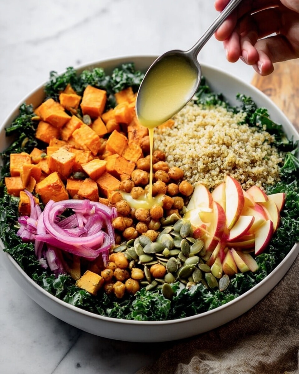 A large white bowl holds a colorful layered salad on a white marbled surface. The base layer is dark green kale leaves spread evenly around the bowl. On top, there are small chunks of orange roasted sweet potato and golden-brown chickpeas placed on one side. Next to them is a pile of pale yellow quinoa grains. Roughly chopped red and yellow apple pieces sit beside the quinoa. A small section has green pumpkin seeds mixed with thin slices of purple pickled onions. A woman's hand holds a spoon pouring a light yellow dressing over the roasted vegetables. Photo taken with an iphone --ar 4:5 --v 7