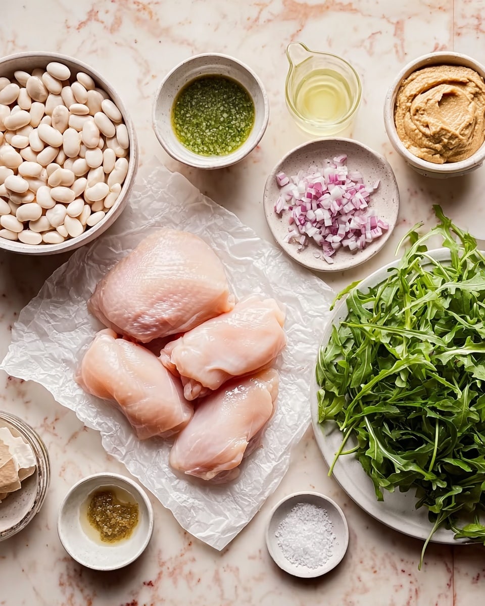 The image shows a collection of raw ingredients arranged neatly on a white marbled surface. In the center, there are four pale pink smooth pieces of raw chicken placed on a piece of white parchment paper. Around the chicken, there is a small white bowl filled with white beans on the left side and a larger white plate filled with green arugula leaves on the right side. There are also several small white bowls containing different ingredients: one with a light green sauce, one with chopped small purple onions, one with a beige mustard-like paste, and a transparent cup with a pale yellow liquid. Additionally, there are two small circular dishes containing coarse salt placed near the sauce and chopped onions. The color palette is soft with natural tones of pink, green, and white. The lighting is soft and natural, highlighting the colors and textures clearly. Photo taken with an iphone --ar 4:5 --v 7