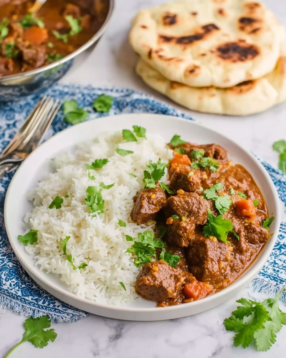 A white plate shows two main layers: on the left is a mound of plain white rice with a soft texture, and on the right is a rich brown stew with small chunks of meat and bits of orange vegetables immersed in a thick sauce. The stew is topped with fresh green cilantro leaves scattered across. Behind the plate, a stack of two pieces of lightly toasted flatbread with some brown char marks rests directly on the white marbled surface. To the left, part of a silver bowl with more stew is visible, along with a fork laid on a blue and white patterned cloth under the plate. Some loose cilantro leaves are scattered on the surface around the plate. photo taken with an iphone --ar 4:5 --v 7