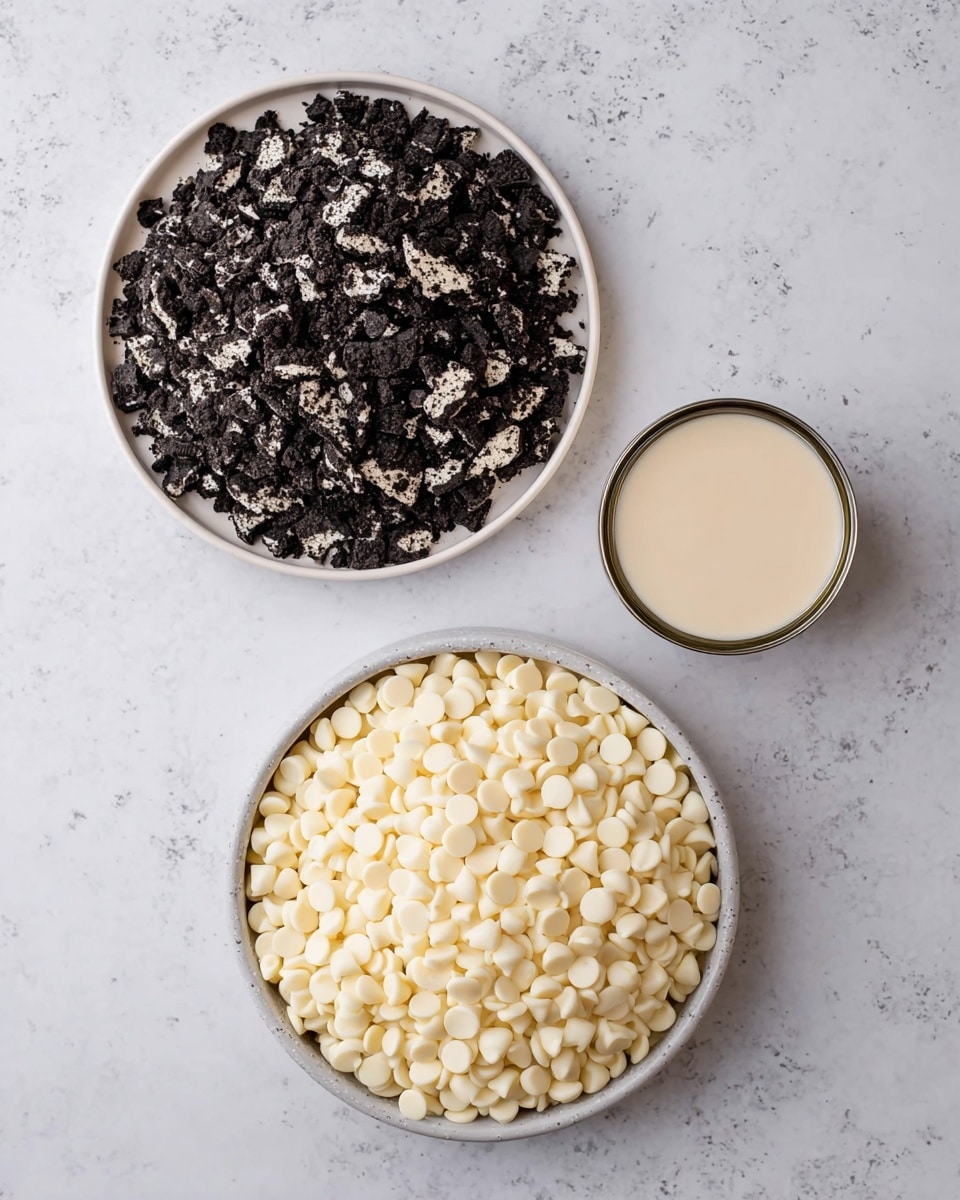 Two white plates sit on a white marbled surface; the top plate is filled with crushed black and white cookies broken into small chunks, creating a rough texture, while the bottom plate holds a mound of small, smooth, round white chocolate chips that cover the plate completely. To the right of the plates is an open small can of light beige condensed milk showing a smooth liquid surface inside. The colors contrast between the dark cookie pieces and pale white chocolate chips accented by the creamy milk. photo taken with an iphone --ar 4:5 --v 7