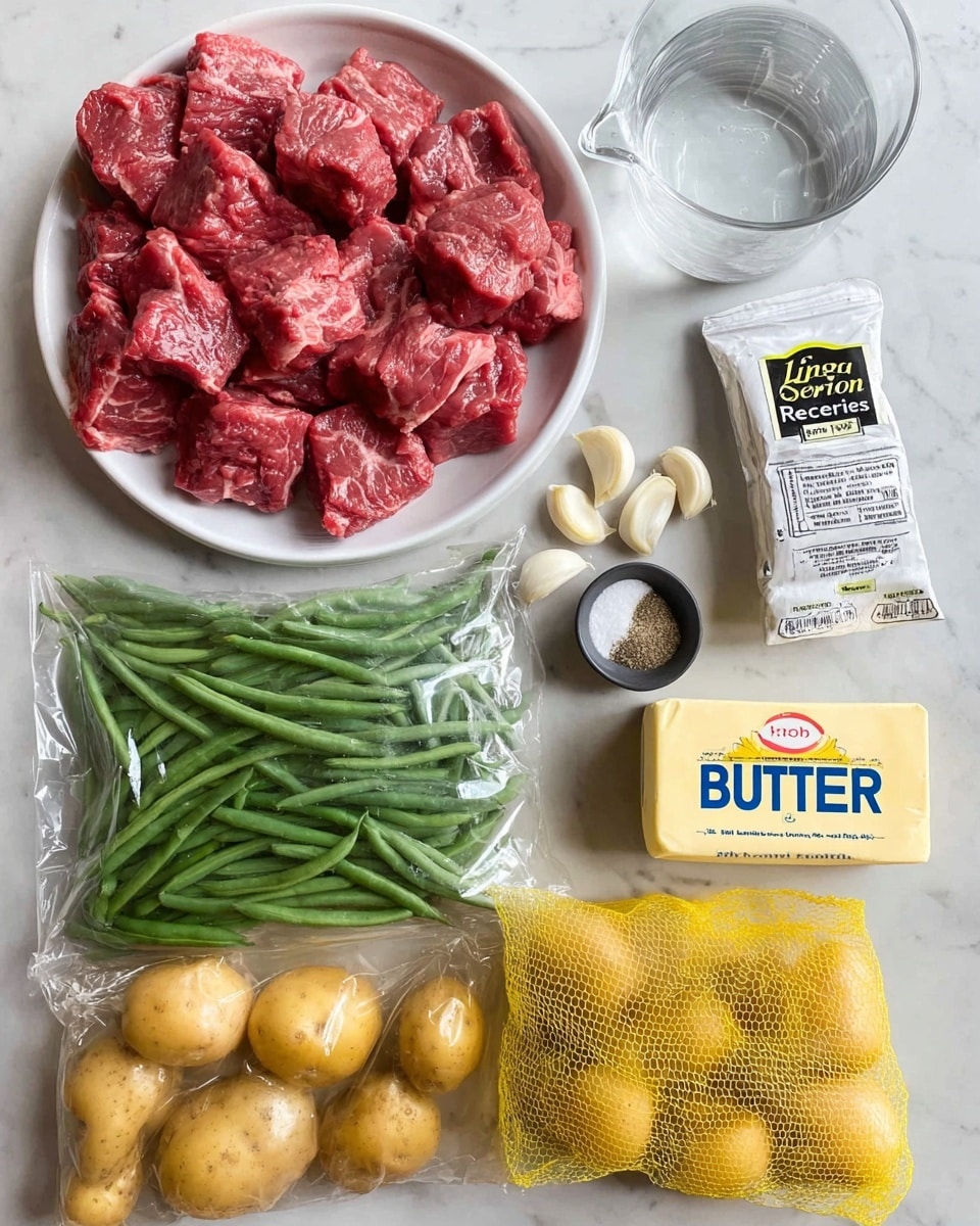 The image shows raw ingredients arranged on a white marbled surface. There is a white dish filled with many pieces of raw red meat with visible marbling, placed at the top left. Below it on the left side, there is a clear plastic bag filled with fresh green beans. Next to the green beans, on the bottom right, is a yellow mesh bag with several small round yellow potatoes inside. Above the potatoes, there are three peeled garlic cloves on the surface. To the right of the garlic, there is a stick of butter with a white wrapper labeled