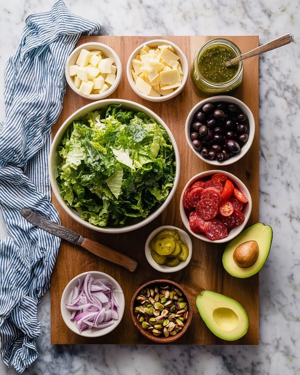 A wooden board placed on a white marbled surface holds a large white bowl in the center filled with dark green torn lettuce. Surrounding it are smaller white bowls and rustic brown bowls with various ingredients: bright red halved cherry tomatoes in the top right, black olives in a white bowl next to diced pale yellow cheese on the top left, yellow-green sliced pickles in a small brown bowl below the cheese, and light purple thinly sliced onions in a white bowl near the bottom left. To the bottom right, a white bowl contains thin slices of reddish salami. Two halves of an avocado are placed on the board, one on the left side and one on the right, showing the smooth green flesh and brown seed. A small brown bowl lower left holds chopped mixed nuts, primarily green pistachios. A clear glass jar with a greenish herb dressing and a spoon sits next to the tomato bowl. Finally, a wooden knife rests at the top left corner of the board, and a crumpled blue and white striped cloth lies beside the board on the marble surface. Photo taken with an iphone --ar 4:5 --v 7