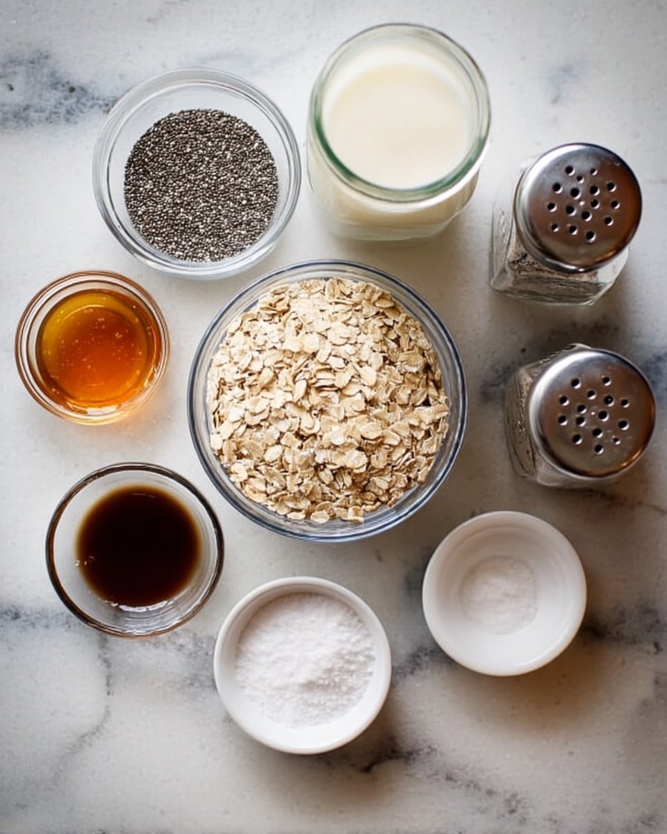 The image shows seven glass bowls and jars with different ingredients arranged on a white marbled surface. In the center, a medium-sized clear bowl is filled with pale beige rolled oats. To its left, a smaller clear bowl holds black and white chia seeds, while below it is a small white bowl with coarse white salt. Next to the salt bowl is a small clear bowl with dark brown vanilla extract. Above the oats bowl, a small clear bowl with amber honey sits beside a tall clear jar filled with white milk. On the far right are two tall metal shakers with perforated tops, partially visible. Photo taken with an iphone --ar 4:5 --v 7