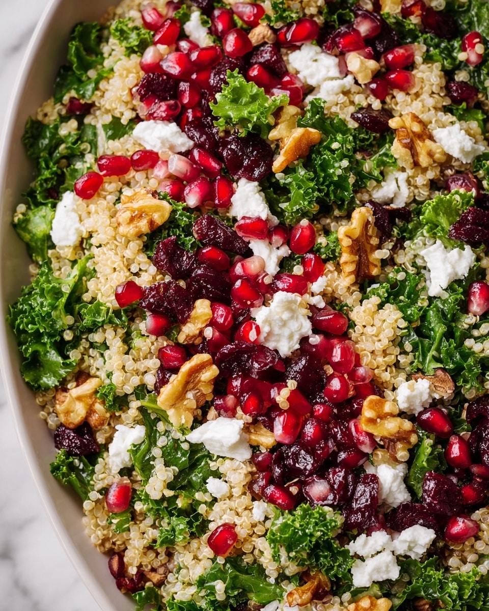 This image shows a close-up of a white bowl filled with a colorful quinoa salad. The bottom layer is beige, fluffy quinoa grains. Mixed in are bright green kale leaves with a leafy texture. Scattered on top are shiny, deep red pomegranate seeds and dark red dried cranberries that add rich color contrast. Small pieces of white goat cheese are spread evenly, offering a soft texture. Golden brown walnut pieces are sprinkled across the salad, adding crunch. The bowl is set on a white marbled surface. photo taken with an iphone --ar 4:5 --v 7