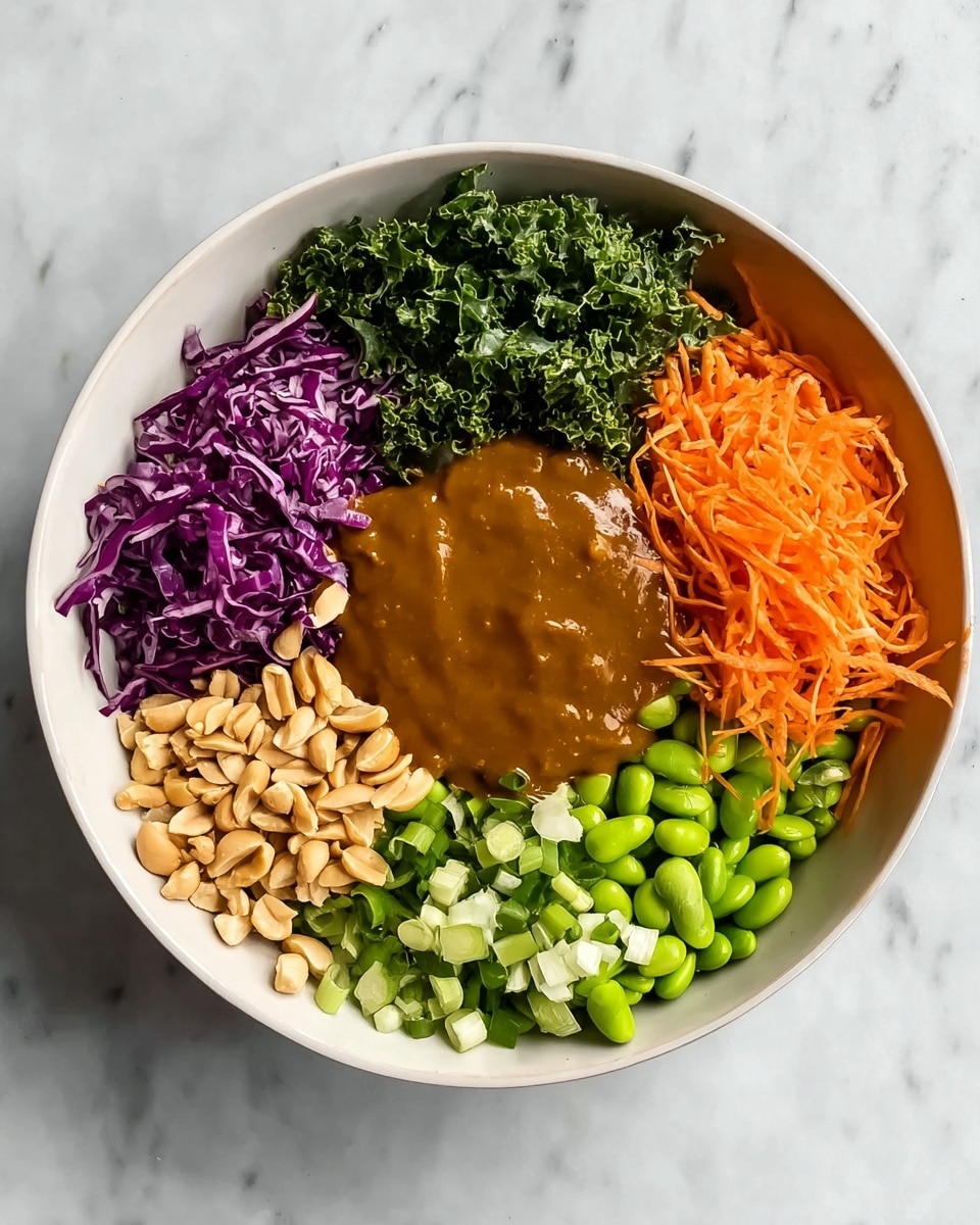 A white bowl sits on a white marbled surface, filled with six neat sections arranged around a thick brown sauce in the center. Starting at the top and moving clockwise, there is a layer of chopped dark green kale with a rough texture, followed by shredded purple cabbage with a crisp look, then chopped green onions with white and green pieces, shredded bright orange carrots that are finely grated, shelled edamame beans in a vibrant light green, and finally, a layer of pale tan peanuts with a smooth but slightly wrinkled texture. The brown sauce in the middle is smooth and glossy, covering the bottom center of the bowl. photo taken with an iphone --ar 4:5 --v 7