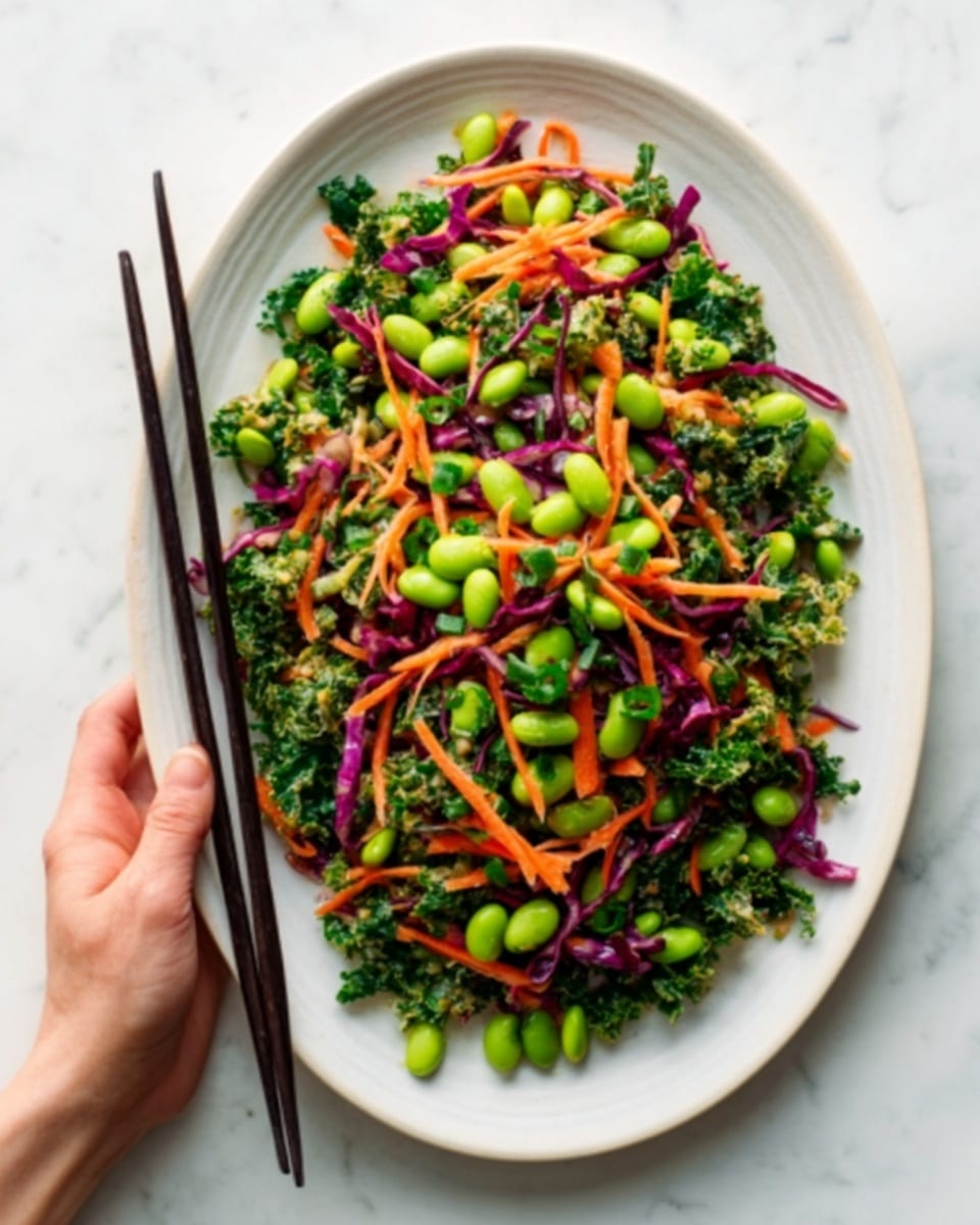 The dish is a colorful salad served on a white oval plate placed on a white marbled surface. The salad has several layers: the base layer is made of chopped green kale leaves with a rough texture, mixed evenly with bright green edamame beans. Scattered on top are thin shredded carrot strips adding a bright orange color. There are also thin slices of deep purple cabbage mixed into the salad, giving a contrast in color. Black chopsticks rest on the left side of the plate, held by a woman's hand. The overall look is fresh and vibrant with a mix of green, orange, and purple colors. photo taken with an iphone --ar 4:5 --v 7