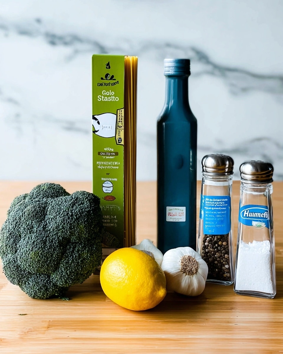 The image shows a group of fresh cooking ingredients placed on a light wooden surface with a white marbled background. From left to right, there is a large, dark green, textured broccoli head in the front. Behind it, a tall, matte blue bottle of olive oil stands straight. Next to it is a tall rectangular green and white box of gluten-free spaghetti pasta, standing vertically. In front of the pasta box is a bright yellow lemon and a white garlic bulb with some brown roots visible. To the right of these is a clear tub of smooth classic hummus with a blue label. Behind the hummus are two clear glass shakers with metal tops; the left one holds coarse white salt, and the right one is filled with whole black peppercorns. The overall setup is clean and simple, with the items spaced evenly across the table. Photo taken with an iphone --ar 4:5 --v 7