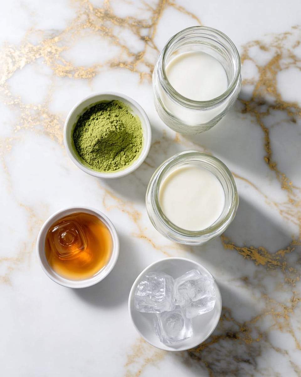 The image shows six containers placed on a white marbled surface with gold veins. There is a small white bowl filled with green matcha powder at the top left, next to two identical clear glass jars filled with white milk on the right side. Below them is a clear glass jar containing water on the left, a small white plate with honey in a light amber color at the bottom left, and a white bowl filled with clear ice cubes at the bottom right. The containers are arranged in a loose circular pattern. The lighting is bright and natural, highlighting the textures and colors clearly. photo taken with an iphone --ar 4:5 --v 7